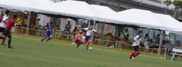 In the background, we can see additional match officials with flag during Deaflympic competition.