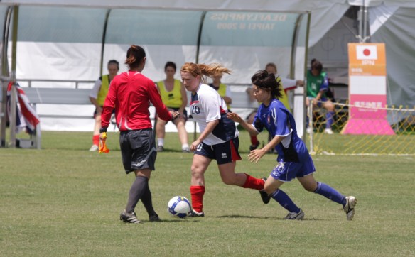 Referee carrying flag during Deaflympics competition.